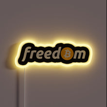 Load image into Gallery viewer, Alt text: “Neon sign with the word ‘freedom’, where the ‘o’ is replaced by a Bitcoin logo, glowing in yellow.”