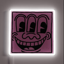 Load image into Gallery viewer, Pop art–style neon sign featuring a quirky purple face with three eyes and a wide grin, outlined by a glowing white neon frame — customneon artwork inspired by Keith Haring