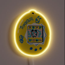 Load image into Gallery viewer, This neon sign captures the nostalgic charm of a classic Tamagotchi, glowing in cheerful yellow with playful pixel art — a perfect tribute to every 90s kid's first digital pet.