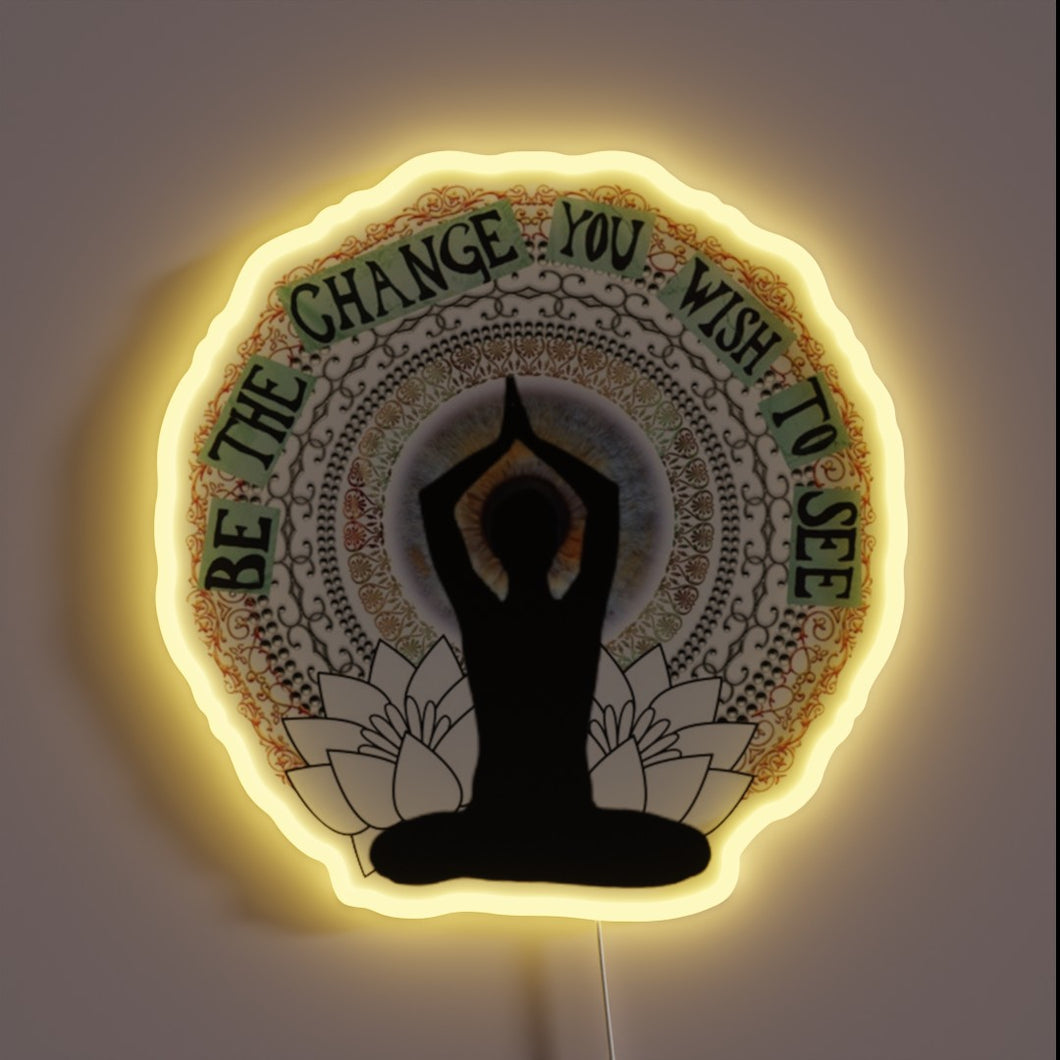 Meditative neon sign with “Be the change you wish to see” quote.