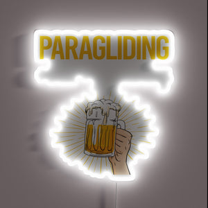Neon Sign Glows Brightly Under Paraglider at Sunset Over Beach