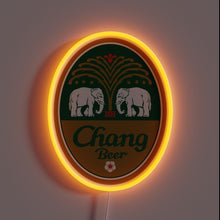 Load image into Gallery viewer, Alt text: *Neon sign in the shape of an oval Chang Beer logo with two white elephants and a glowing orange border.*