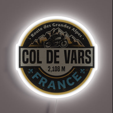 Neon wall art featuring **Col de Vars** badge with a motorcycle and alpine mountain scene — a rugged tribute to the French Alps for motorbike lovers and adventurers.