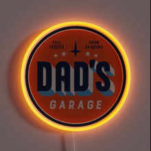 Load image into Gallery viewer, Retro-style neon sign reading “Dad’s Garage” with “Full Service” and “Open 24 Hours” in small text. The circular sign glows with a warm orange neon border.