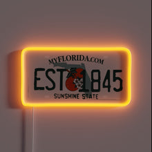 Load image into Gallery viewer, Neon sign of a Florida license plate with &quot;EST 1845&quot; and orange glow.