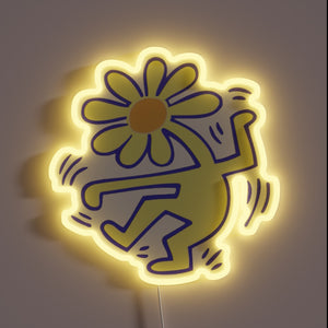 Neon sign of a dancing figure with a daisy flower head and yellow glow.