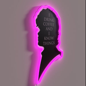 Neon sign declaring love of coffee and intellectual humor