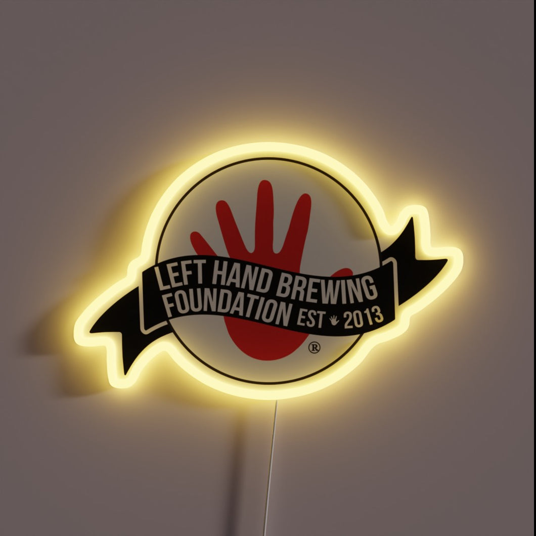 Bright customneon sign displaying the Left Hand Brewing Foundation logo with a bold red hand symbol and a black banner 