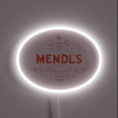 Mendl’s Patisserie neon sign in vintage oval design with glowing white border.