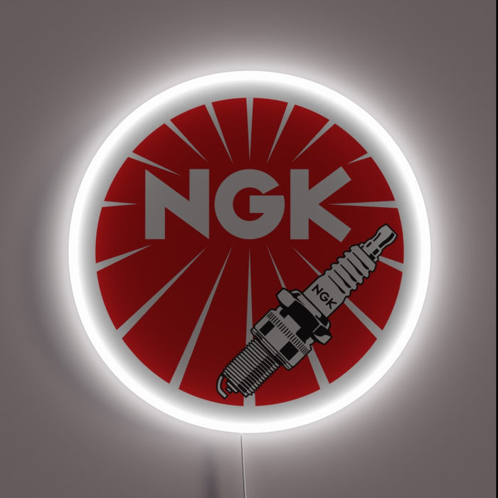 Red NGK spark plugs neon sign with bold white lettering and spark plug graphic.