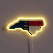 Load image into Gallery viewer, Neon sign shaped like North Carolina with the state flag and yellow glow.
