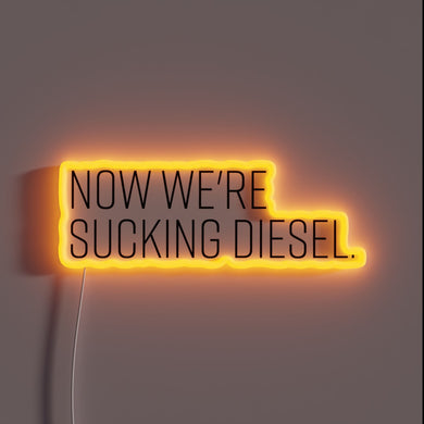 Neon sign with 'Now We're Sucking Diesel' in bold script.