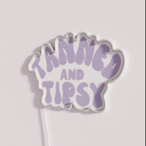 Vibrant purple neon bar decor with tanned tipsy sentiment ambiance.