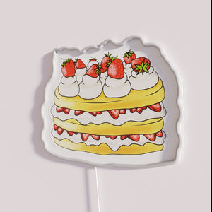 Vibrant neon dessert display decoration with semi-realistic strawberry shortcake design