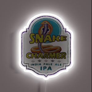 Vibrant snake charmer figurine illuminated by colorful RGB neon lights.