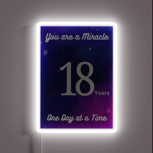 Neon celebration of 18 years sober in vibrant rainbow colors.