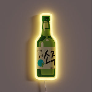 Green soju bottle neon sign with Korean text and a yellow glow.
