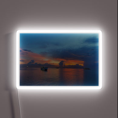 Vibrant Neon Sign Featuring Sunset Scene with Passing Cruise Ships