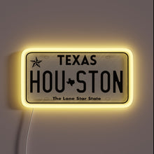 Load image into Gallery viewer, Houston Texas license plate neon sign with yellow glow.