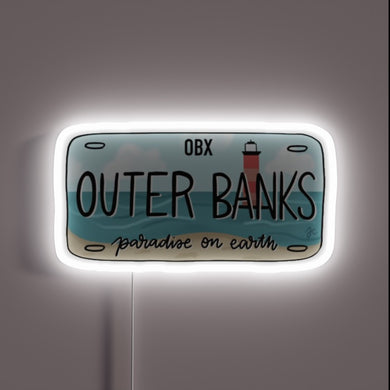 Outer Banks license plate design with beach and lighthouse, glowing white neon outline.
