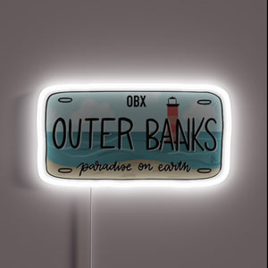 Outer Banks license plate design with beach and lighthouse, glowing white neon outline.
